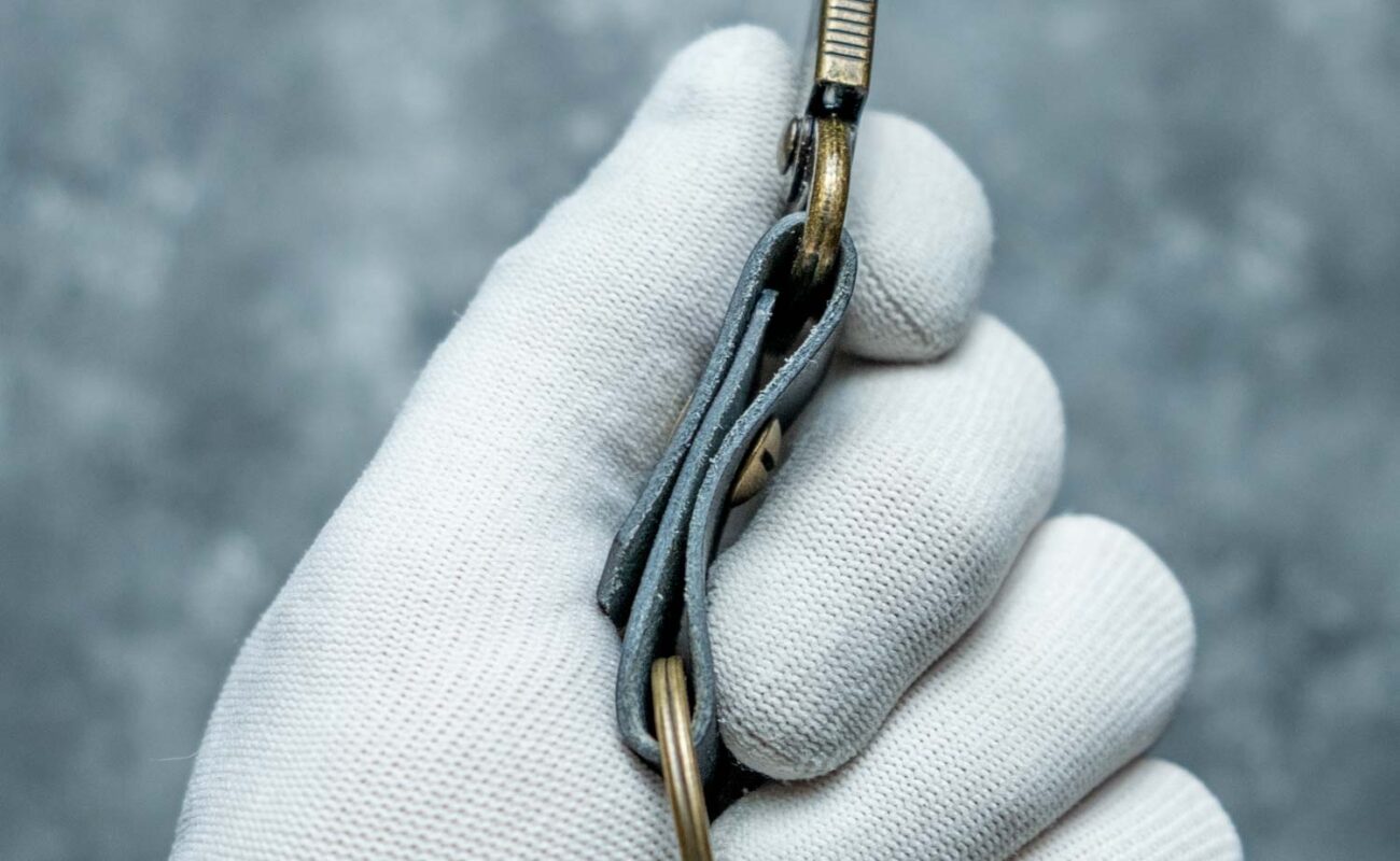 Breloc piele cu carabină navy, detaliu hardware gold antichizat și șurub chicago, prindere dublă pe piele tăbăcită vegetal