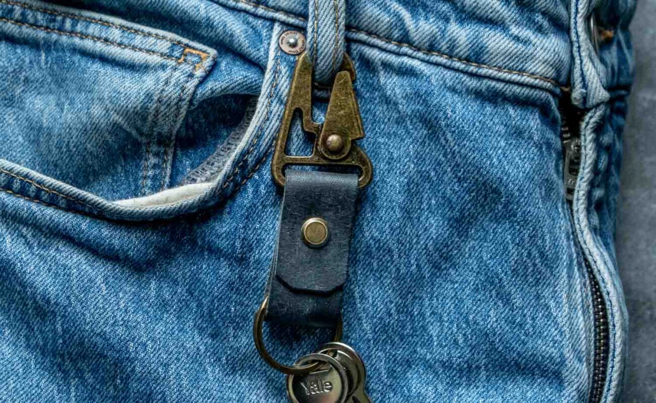 Breloc piele cu carabină albastru navy pe blugi, vedere de ansamblu, utilizare zilnică, șurub chicago și carabină gold antichizat
