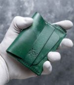 Portofel minimalist Valkyrie verde emerald, detaliu logo embossat, ață neagră saddle stitch, piele naturală tăbăcită vegetal