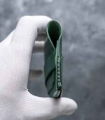 Portofel minimalist Valkyrie verde emerald vedere laterală, profil slim, cusătură neagră saddle stitch, piele naturală premium