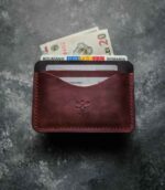 Portcard slim buletin vișiniu, detaliu cusătură saddle stitch manuală, logo embossat, piele naturală premium