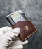 Portofel barbati pentru carduri, piele negru și maro, vedere laterală cu carduri și bancnotă în ambele buzunare, logo gold embosat, cusătură galbenă, handmade România