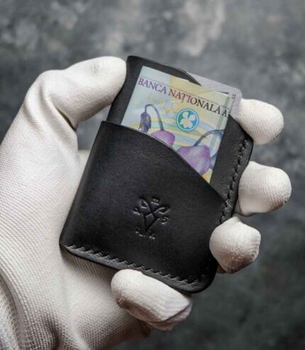 Portofel barbati pentru carduri, piele neagră mat, vedere frontală cu bancnotă introdusă în buzunar, logo embosat, cusătură neagră, handmade România