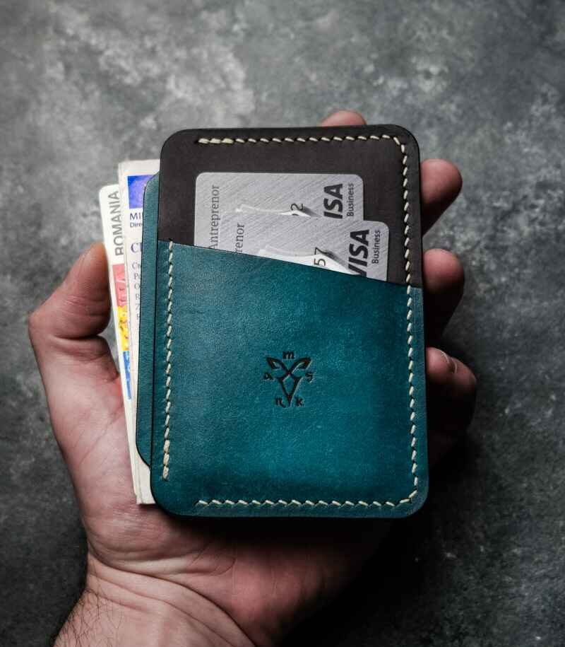Portcard Talon Auto turcoaz și antracit bicolor, ținut în mână cu buletin și carduri introduse în buzunare, logo embosat, piele naturală, handmade România