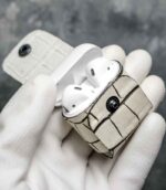 Husă AirPods 2 alb vedere laterală, profil, piele naturală tăbăcită vegetal, capsă neagră, canturi vopsite