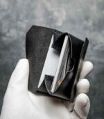 Portofel barbati pentru carduri, piele neagră lucioasă, deschis în unghi cu card introdus, cusătură neagră, fără logo, handmade România