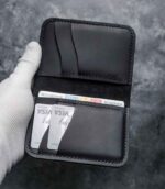 Portofel negru Arkano vedere față portofel închis cu logo vizibil, ață neagră, logo embosat, piele naturală, 7 buzunare, personalizabil cu inițiale