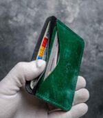 Portcard slim buletin verde emerald, detaliu cusătură saddle stitch manuală, logo embossat, piele naturală premium