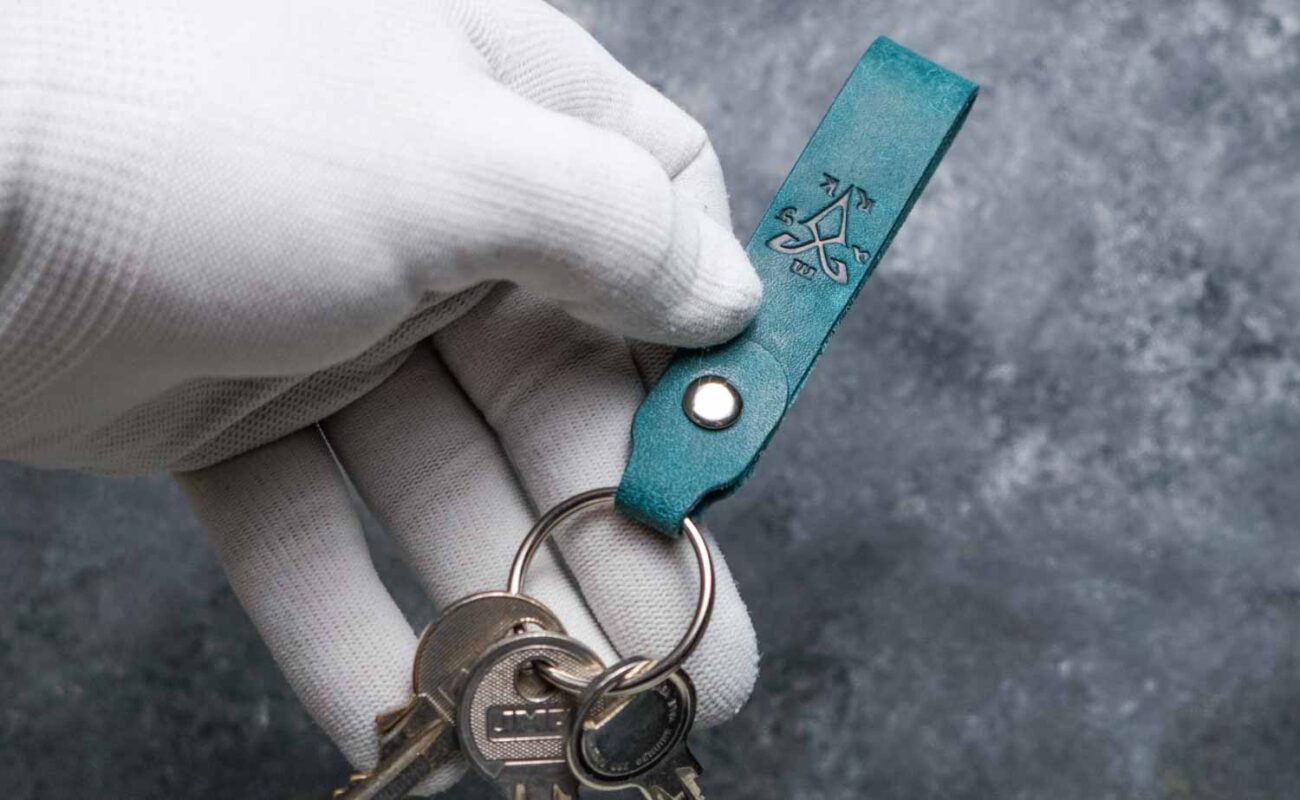 Breloc piele naturală turcoaz cu inel silver ținut în mână alături de chei, handmade România